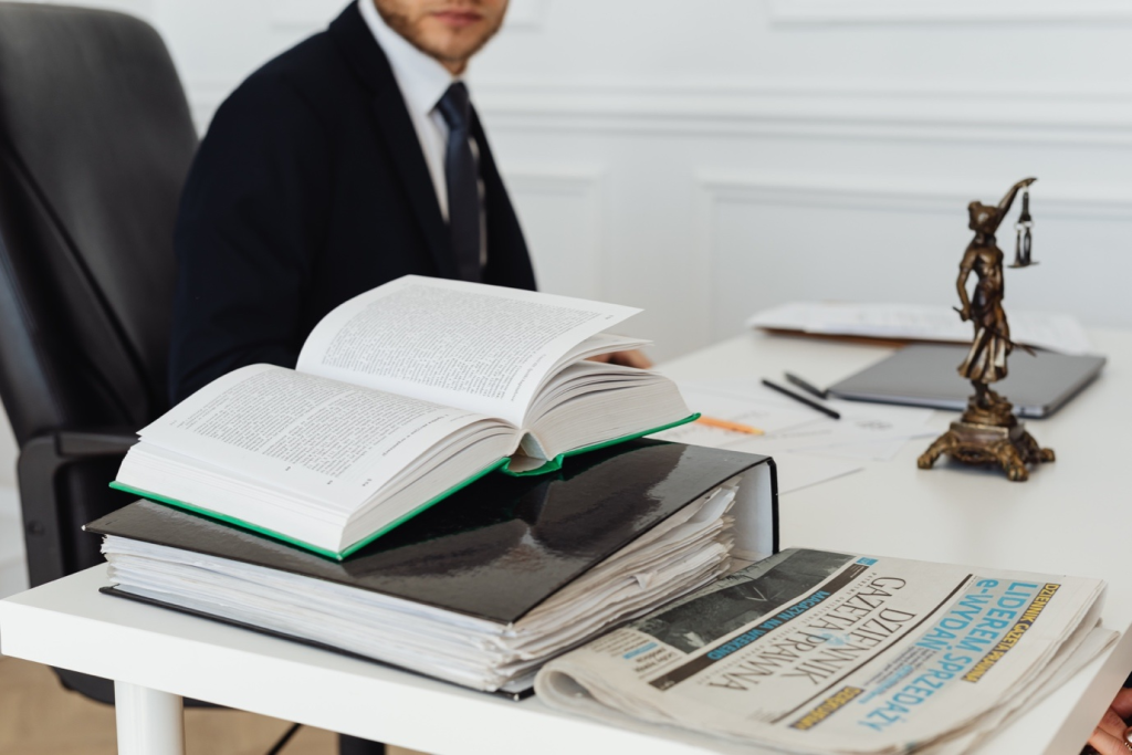 Lawyer working with an open book, big folder, and papers on white table