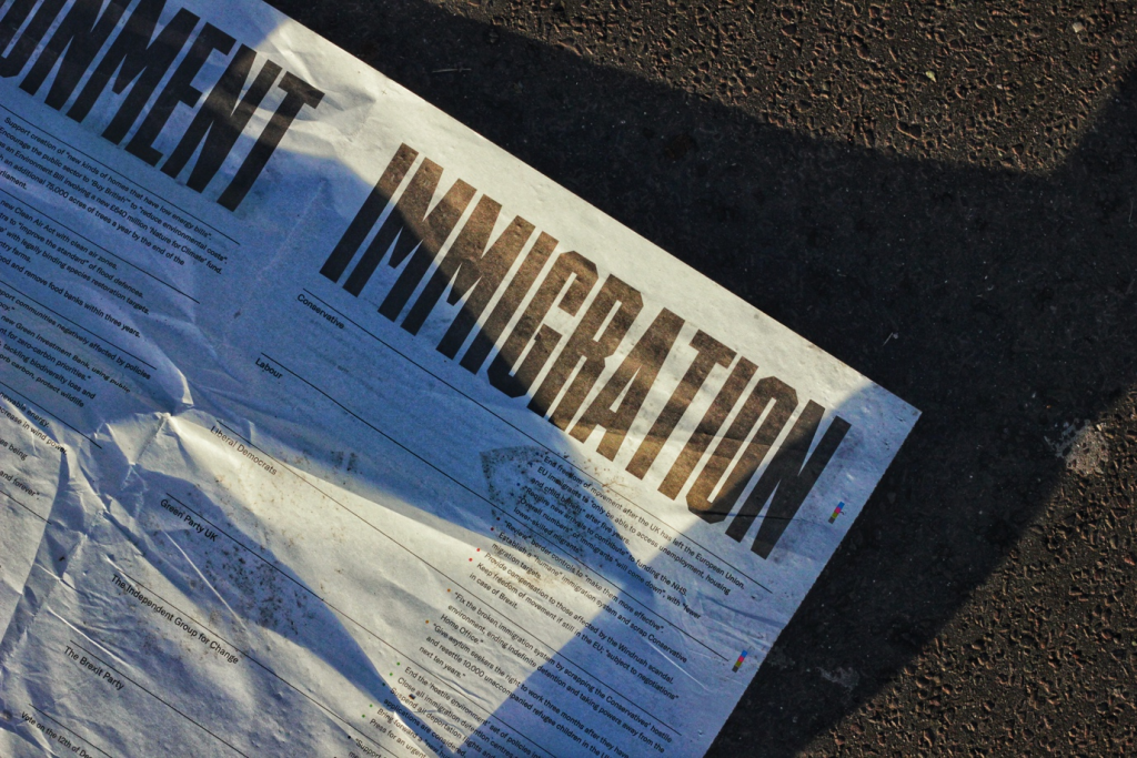 Paper with 'immigration' as headline thrown on the sidewalk
